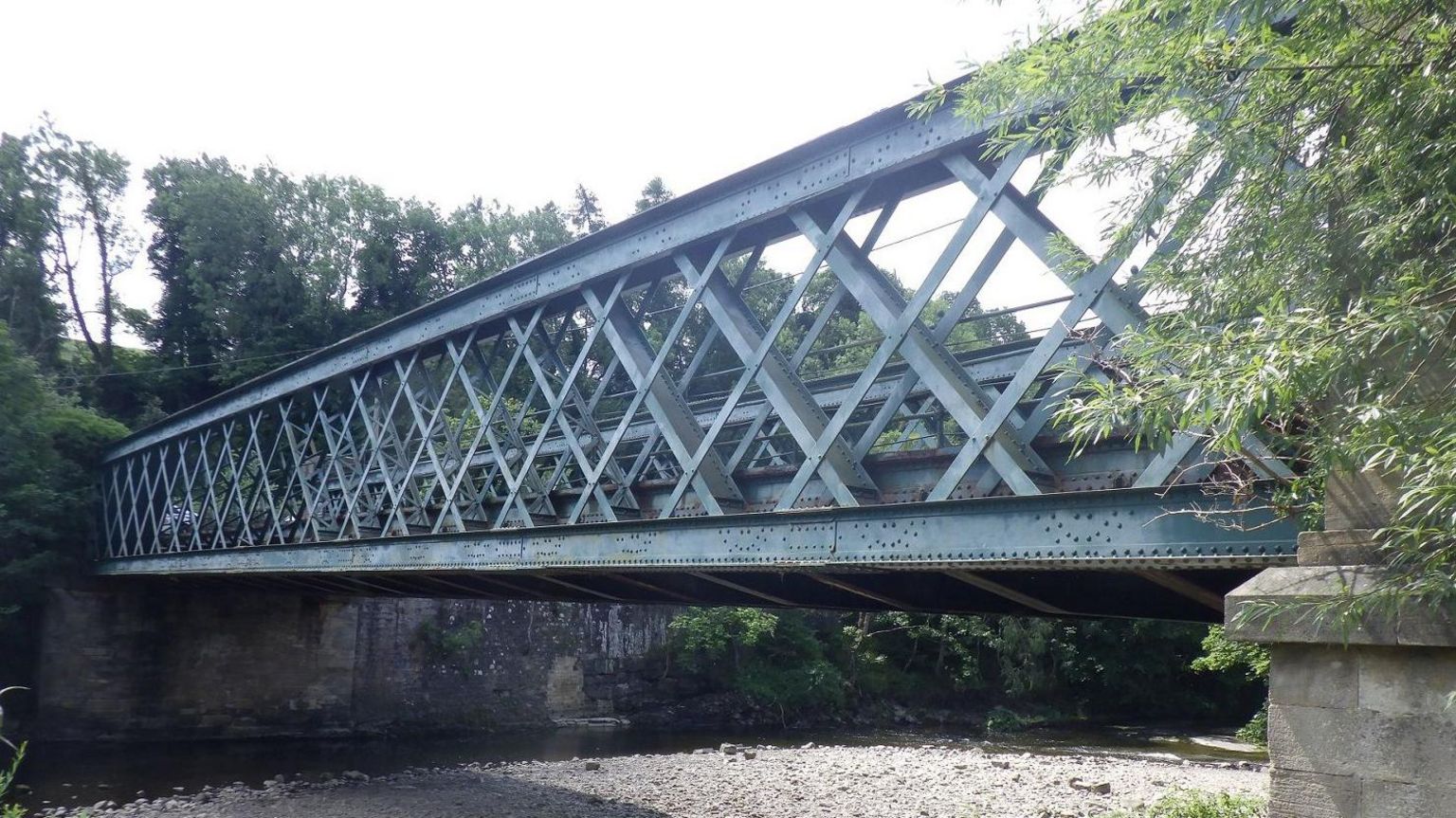 A blue steel bridge across a river.