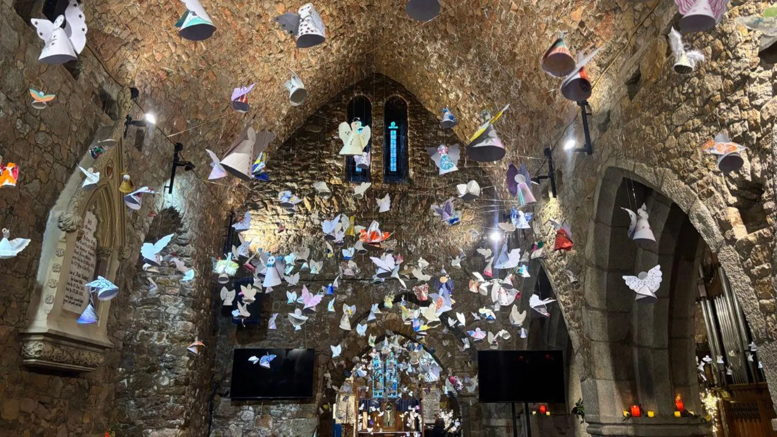 Cientos de ángeles de papel colocados en la iglesia