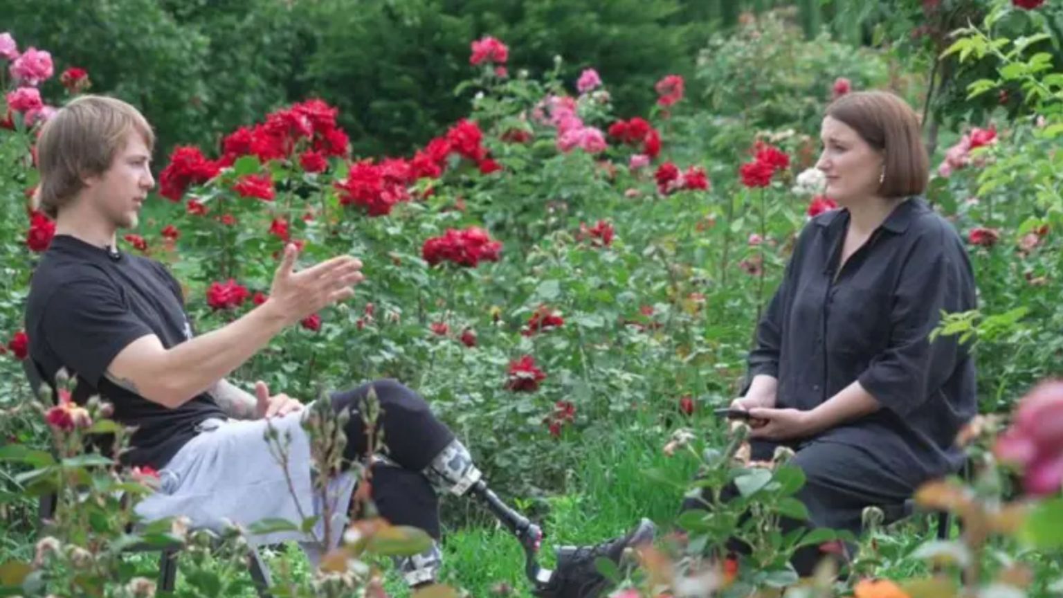 A man and a woman in a rose garden