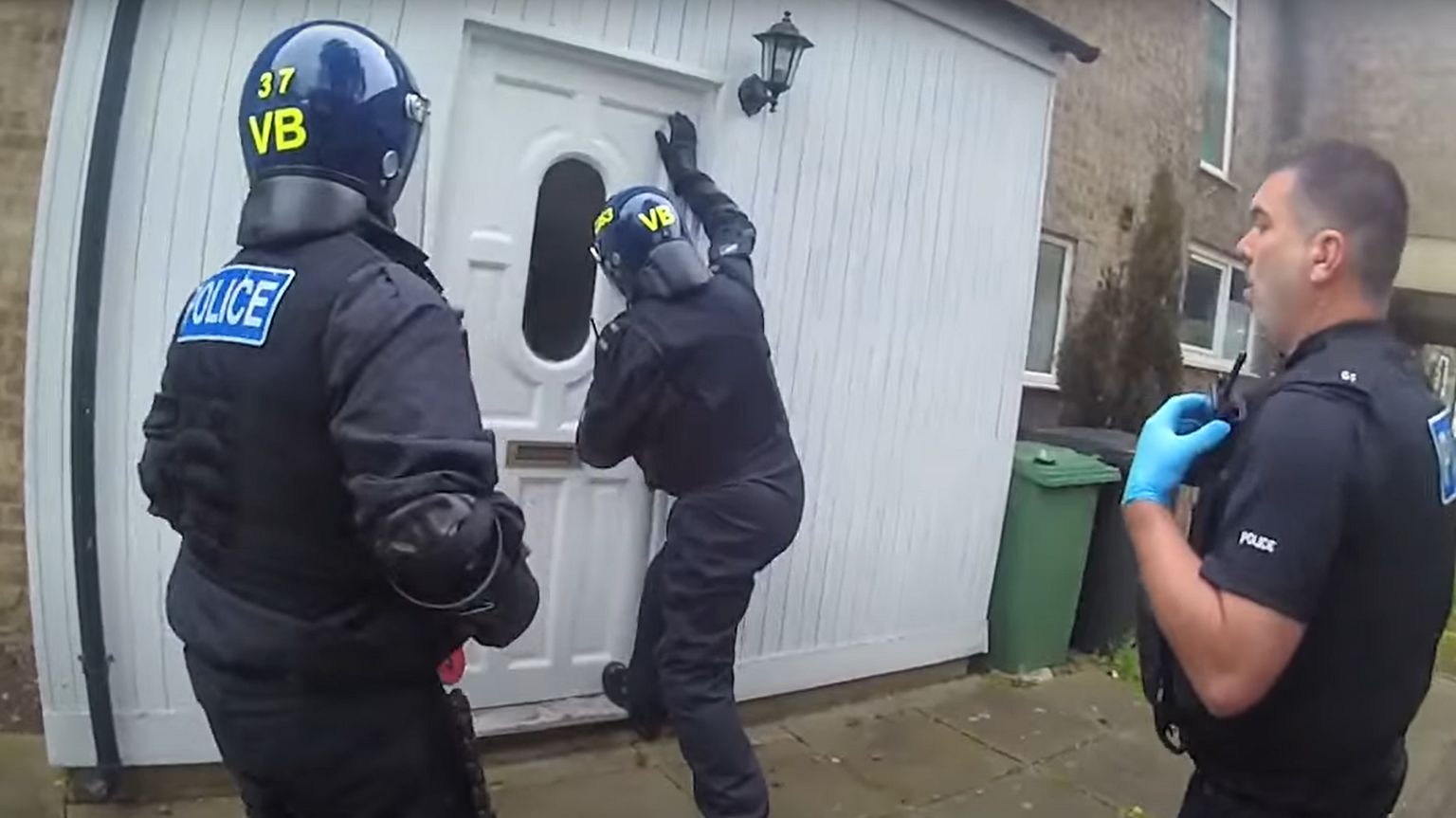 Police officers breaking into a property for a raid 
