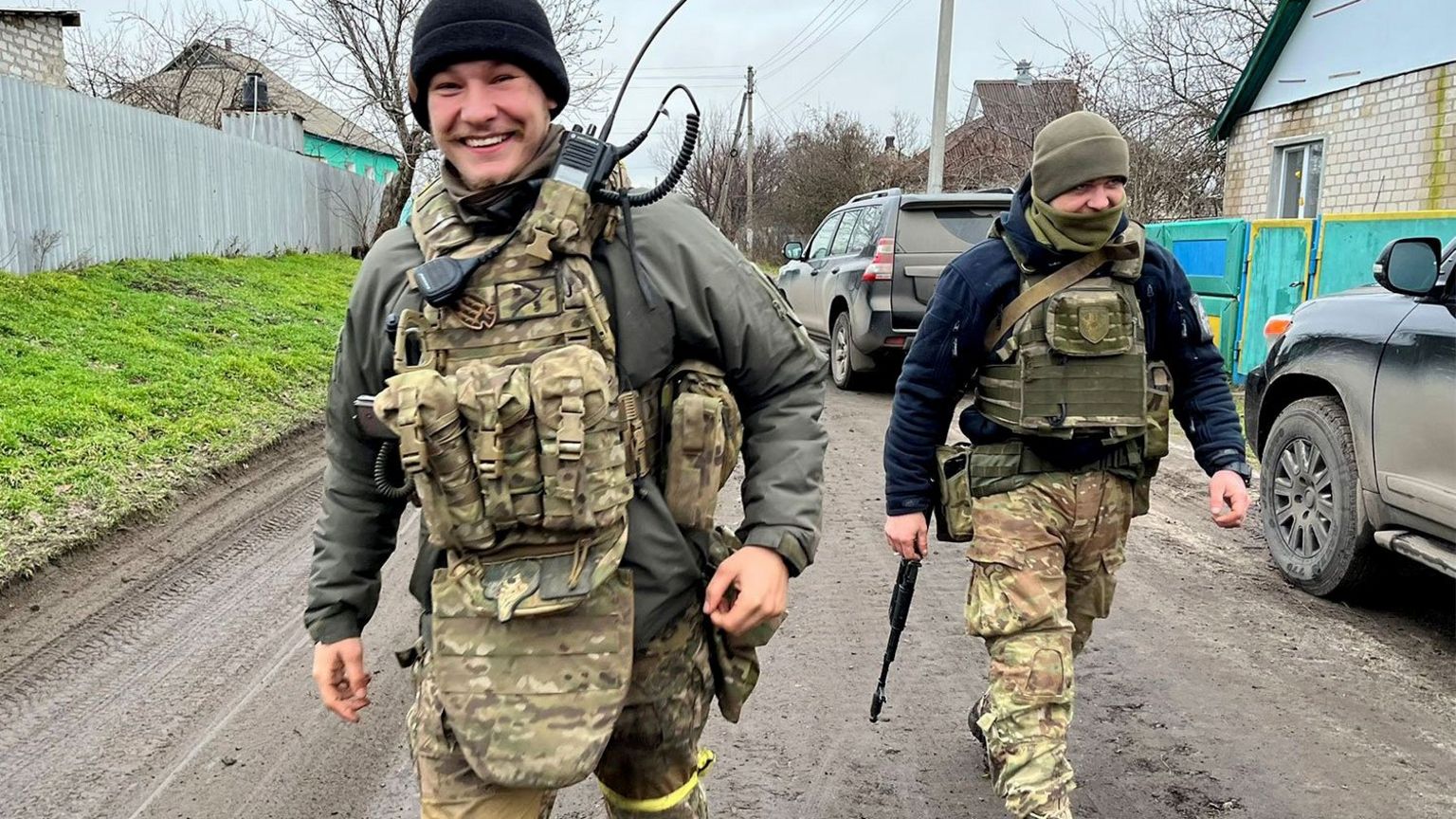 Eugene smiling in military gear with a comrade