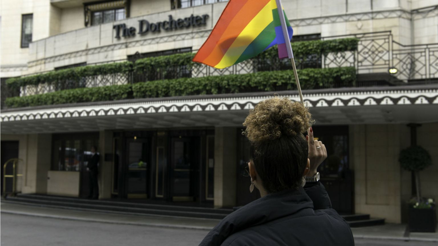A protester seen holding an LGBT flag outside the Dorchester hotel during the protest condemning the new Brunei laws