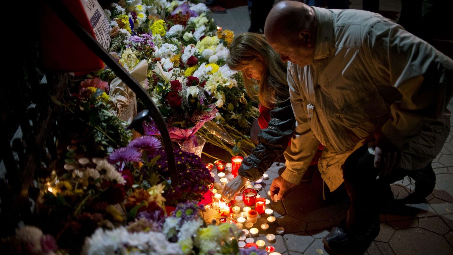 People light candles in Paris at a makeshift memorial