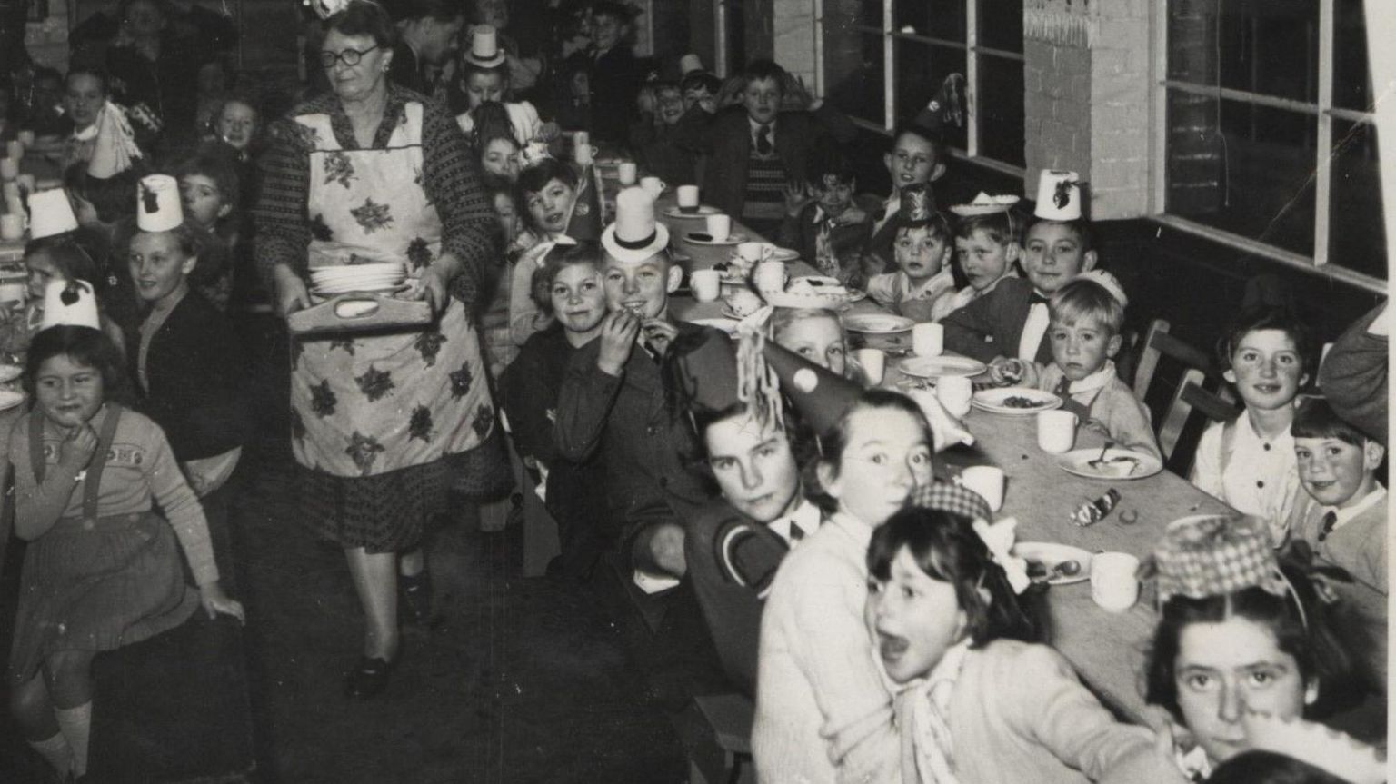 Children at tables for the factory's Christmas party in 1957.