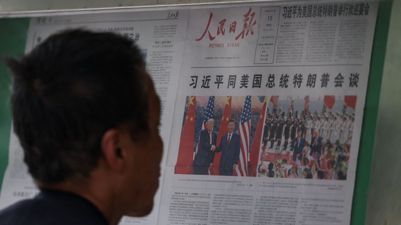 北京街头某读报栏前一位市民查看当天中共《人民日报》对习近平与特朗普会晤的头版头条报导(15/5/2026)