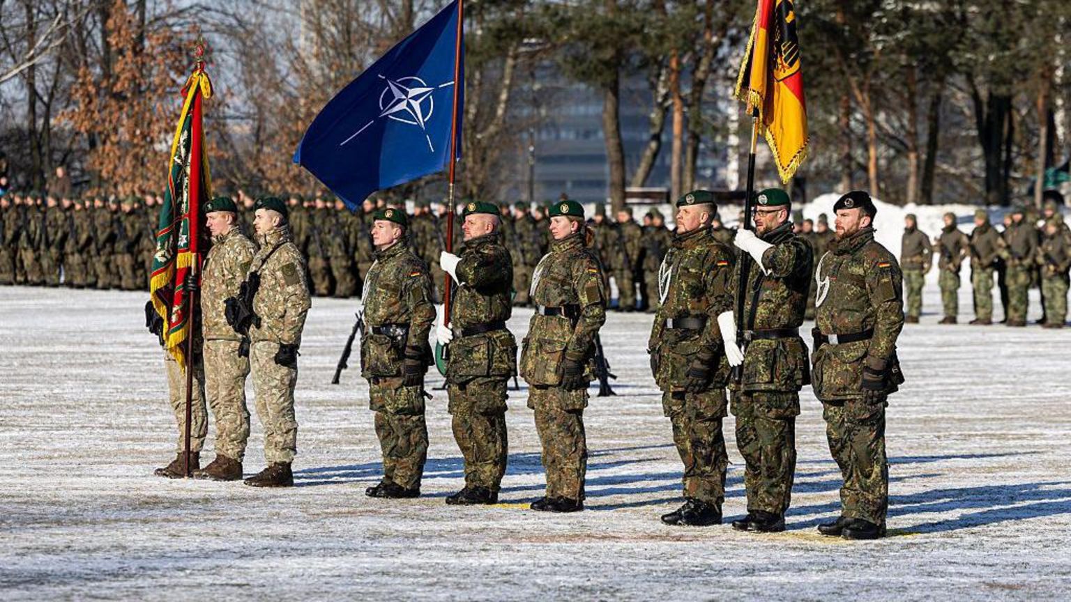 德国士兵身穿绿色迷彩军服，在2026年2月4日于立陶宛考纳斯举行的公开仪式上列队行进并高举北约旗帜，标志德国扩大对立陶宛的军事承诺