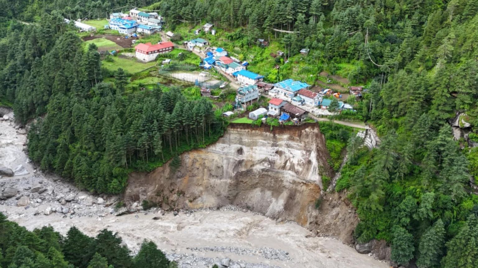 An aerial view of a village in the Khumbu Valley where the hillside has been shorn away.