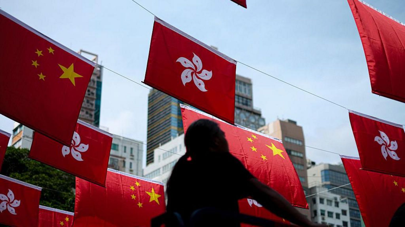 在香港，工人们香港移交主权纪念日到来之前，悬挂中国国旗和香港旗帜。