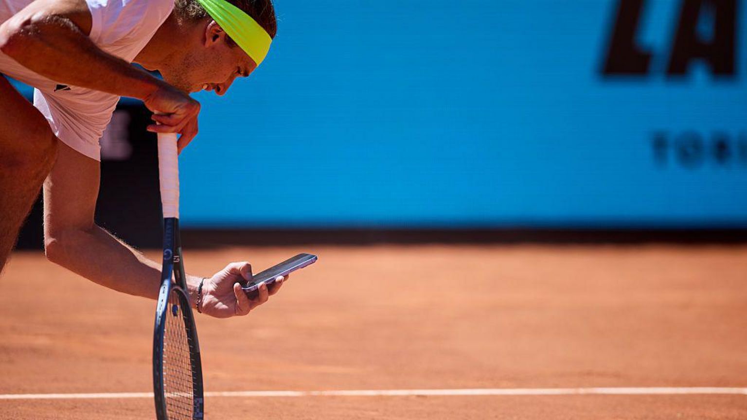 球手亚历山大·兹维列夫(Alexander Zverev)用手机在红土场上拍摄球印