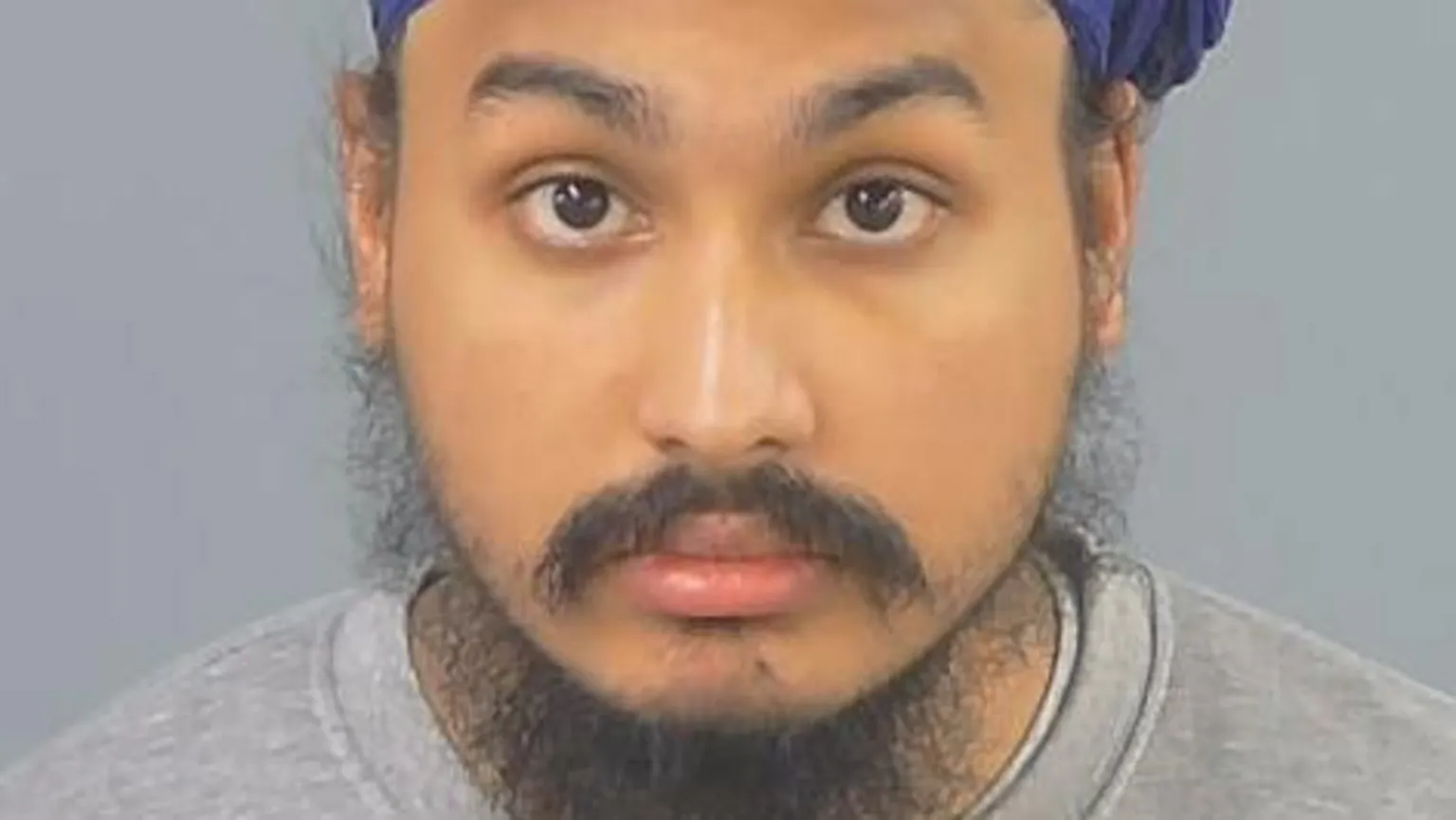 Police handout Custody photo of Vickrum Digwa, a man with a beard, a grey jumper and a purple turban looking to the camera.
