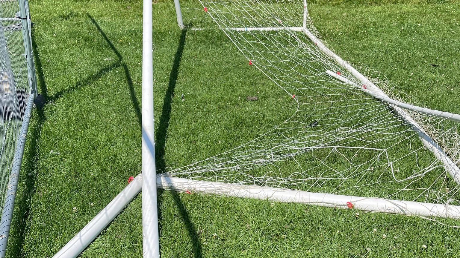 A close-up picture of a goal broken on grass