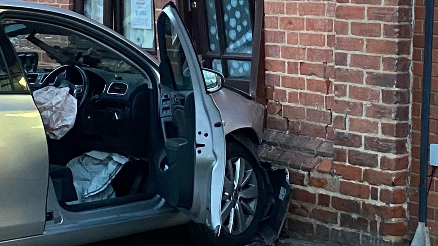 A close up of a silver car embedded in a church wall