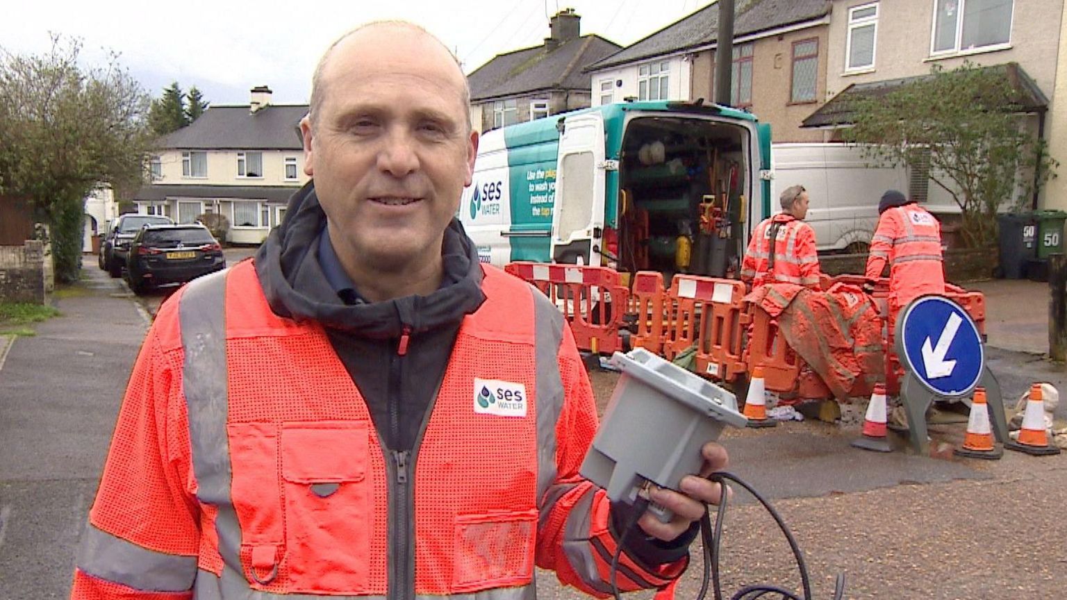 Jeremy Heath wearing a hi-vis jacket holding one of the devices