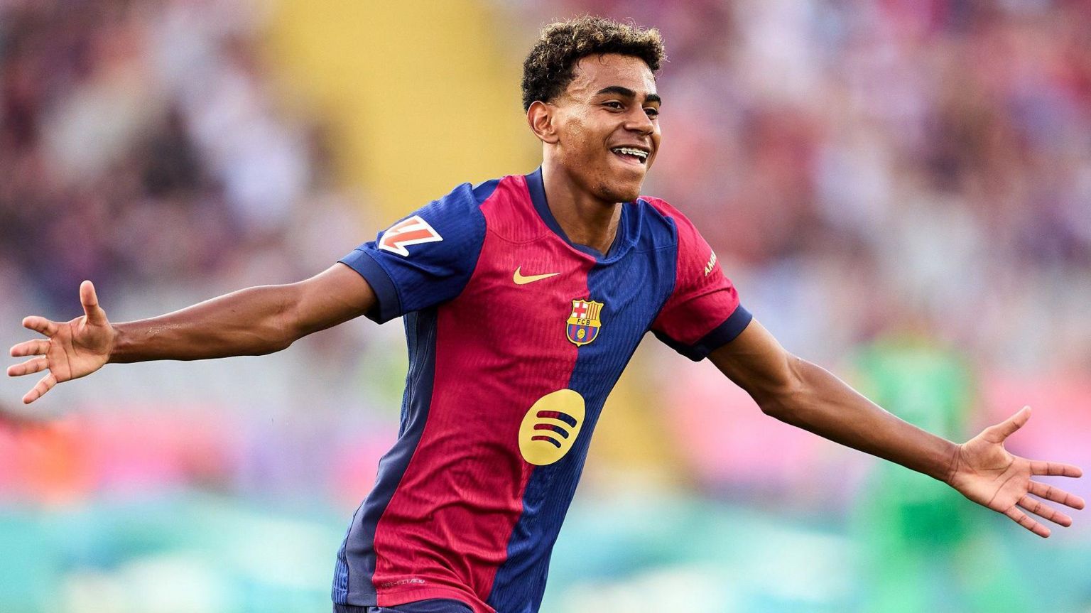 Barcelona's Lamine Yamal stretches his arms out in celebration after scoring against Athletic Bilbao