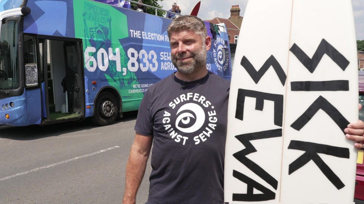 Giles Bristow was at the protest for Surfers Against Sewage stood with a surfboard and in front of a blue coloured bus with facts and figures on the side