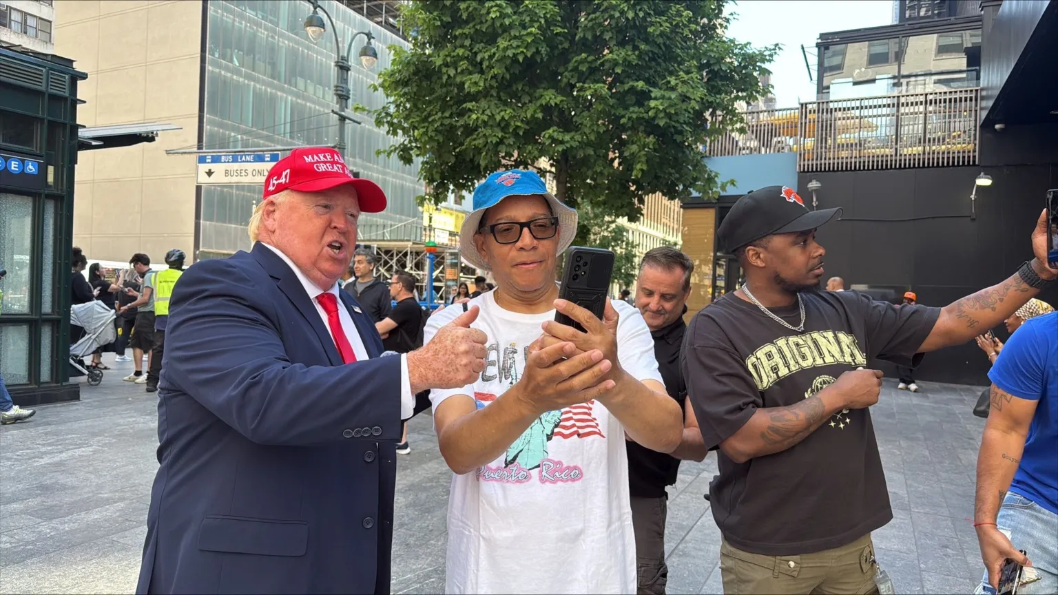 Kayla Epstein / BBC A Trump impersonator outside Madison Square Garden poses for photos with tourists and Knicks fans.