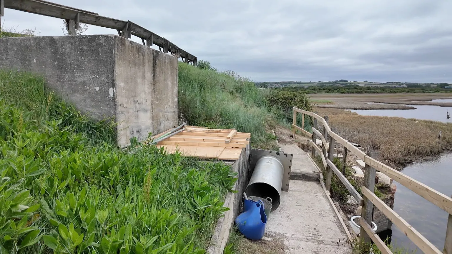 Wooden boards cover the concrete structure where contractors have installed another temporary fix to the failing tidal flap