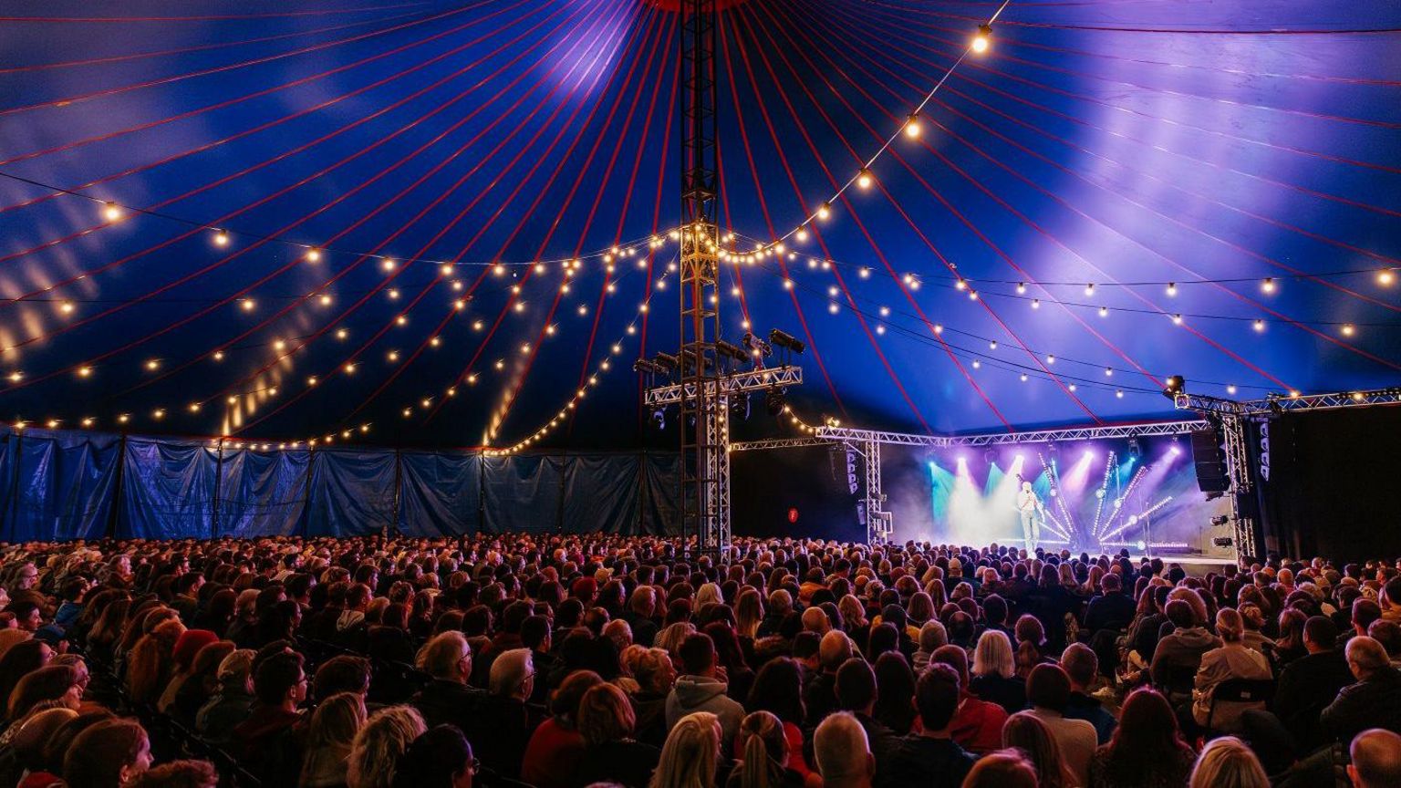 Hundreds of people sitting inside the tent at Bristol Comedy Garden