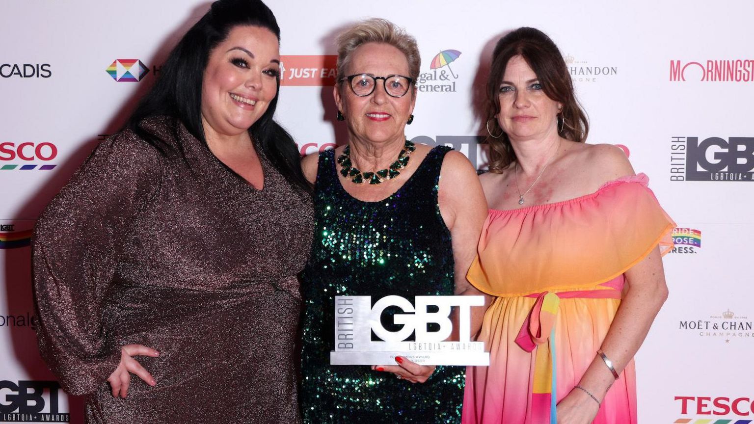 Three women pose with silver British LGBT Award