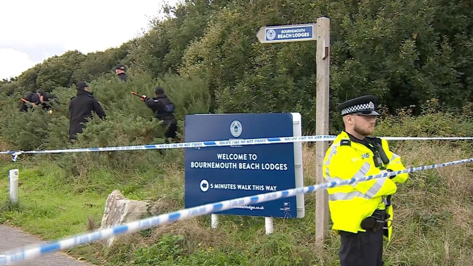 Police cordon in Boscombe and officers searching undergrowth