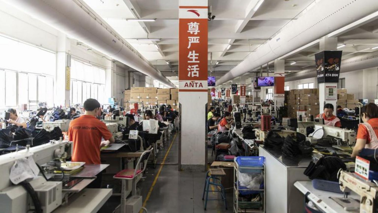 在晋江一间安踏工厂的制鞋生产线上，一根立柱上展示着写有“尊严生活”的中文标语