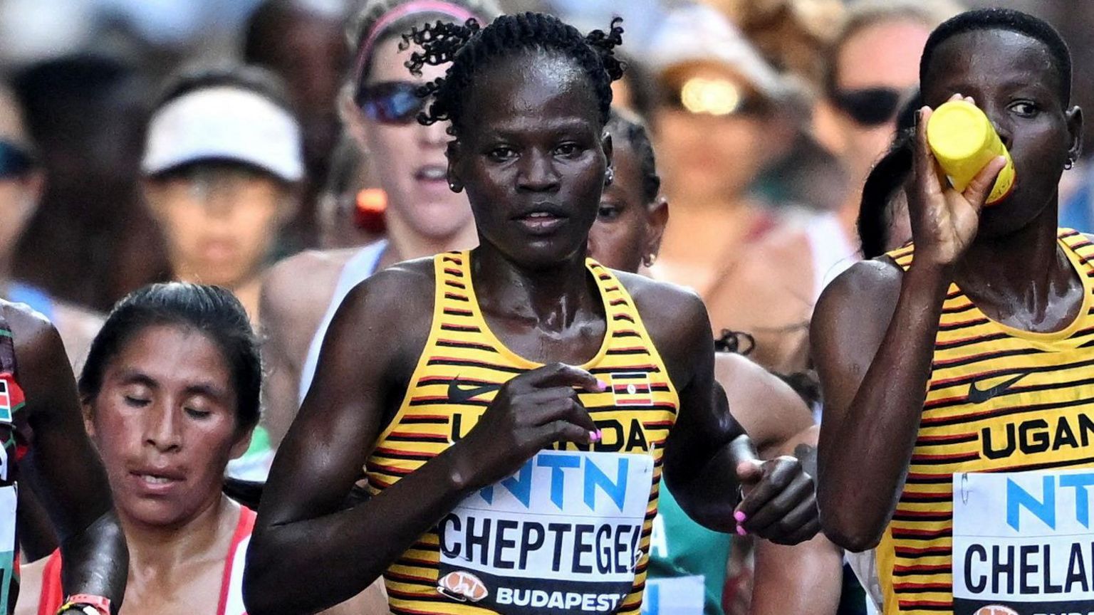 Rebecca Cheptegei running in a race with a crowd of other people