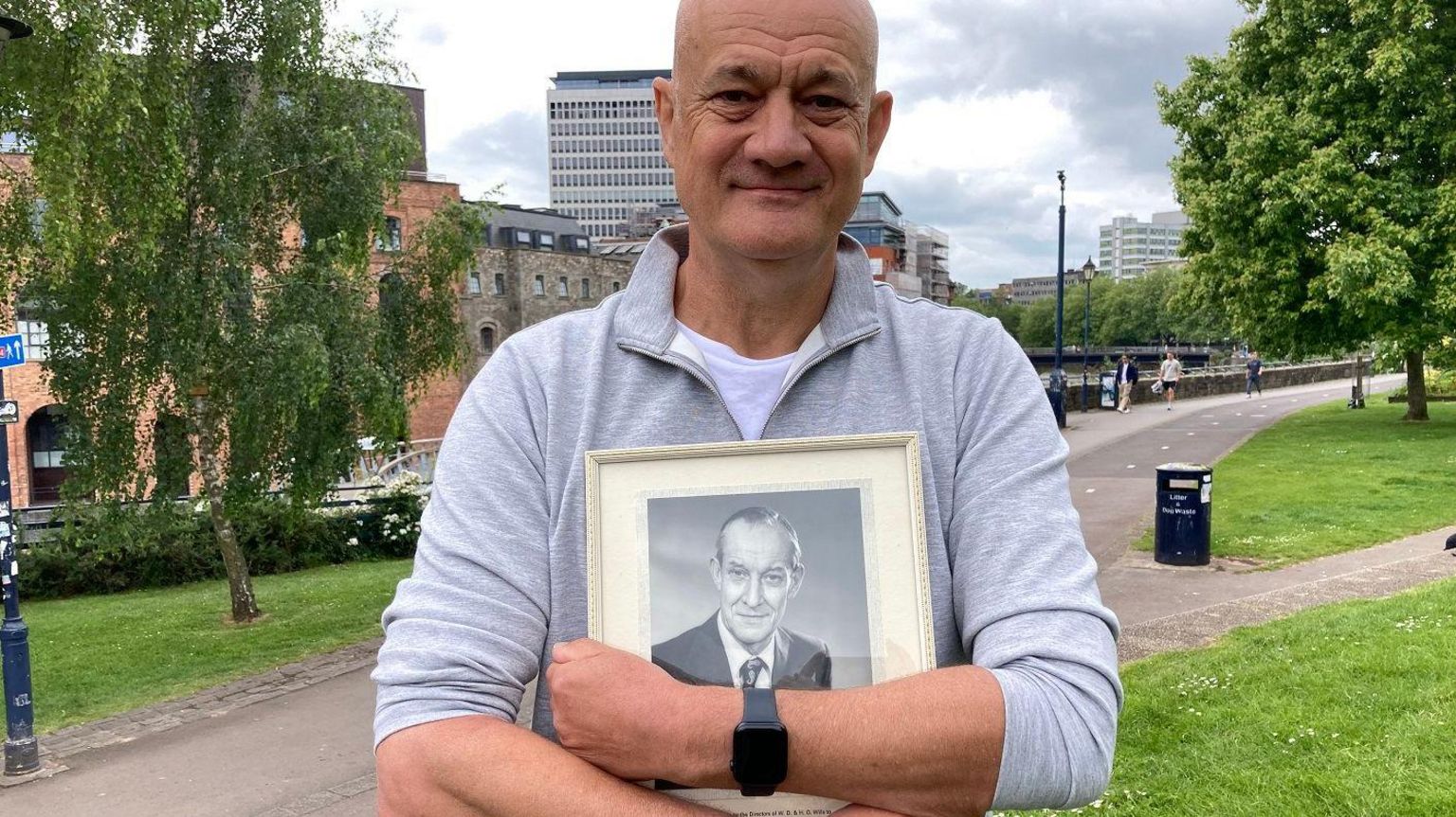 Peter Rowe holds a picture of his father at the D-Day memorial in Castle Park in Bristol