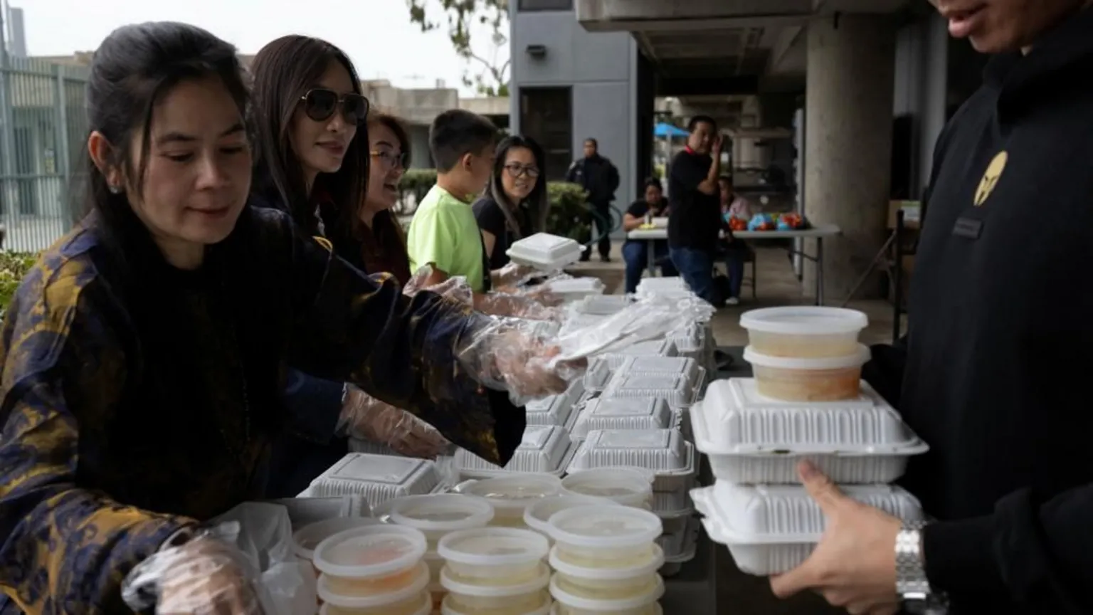 Reuters Several people organise parcels of food for distribution at an evacuation centre