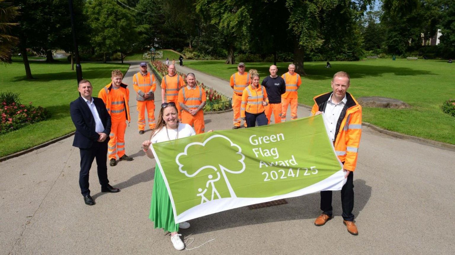 Park staff and council officials holding a green flag in Mowbray Park