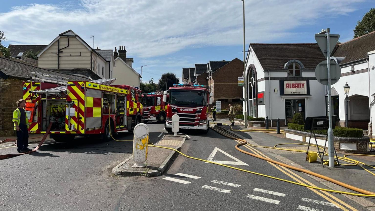 Three fire engines parked on Hadham Road with hoses strewn across the street