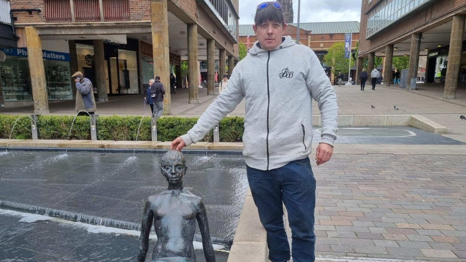 The Naiad statue in Coventry and a man next to it