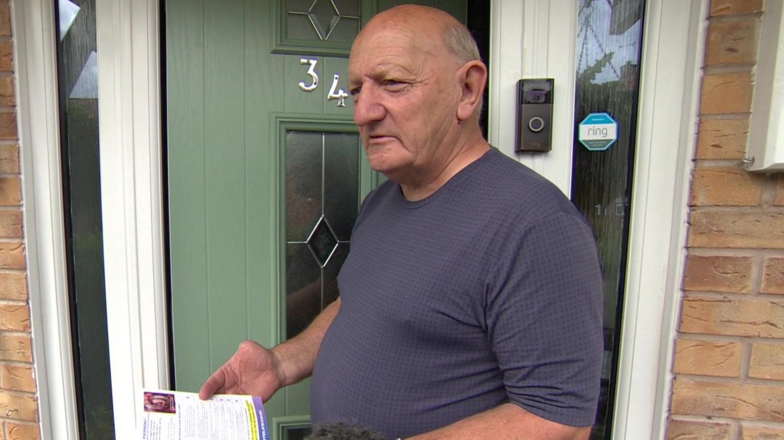 David Brown holding a leaflet outside a home in Kingswood, Hull