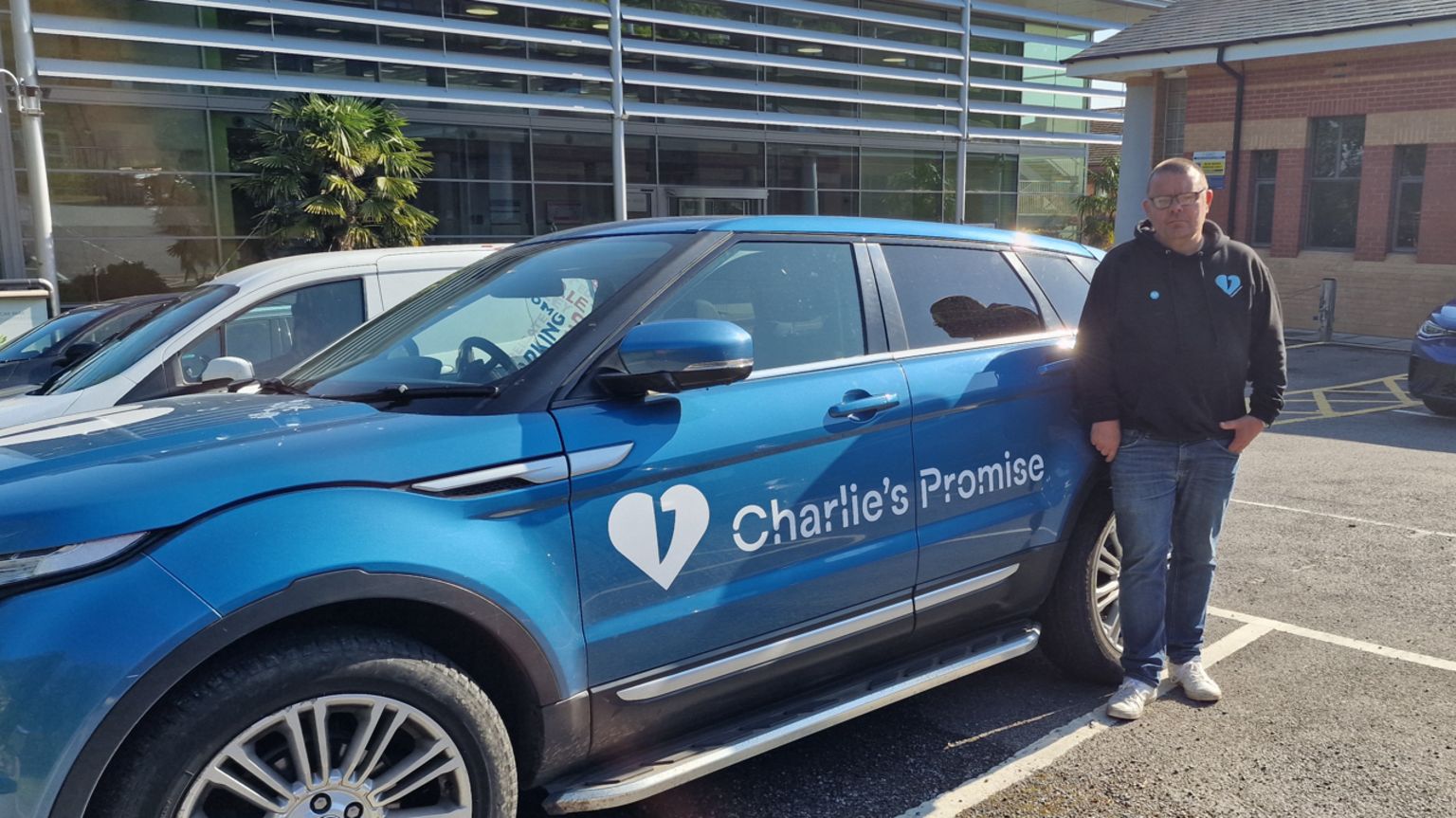 Martin Cosser with his car branded with Charlie's Promise in Guildford