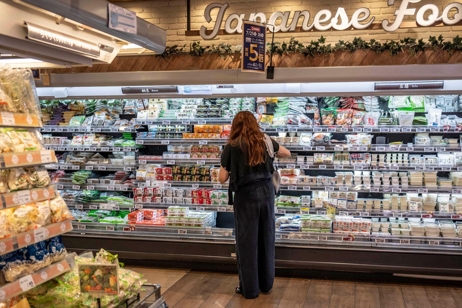 2026年7月24日，一名顾客在东京一间超市选购食品杂货。