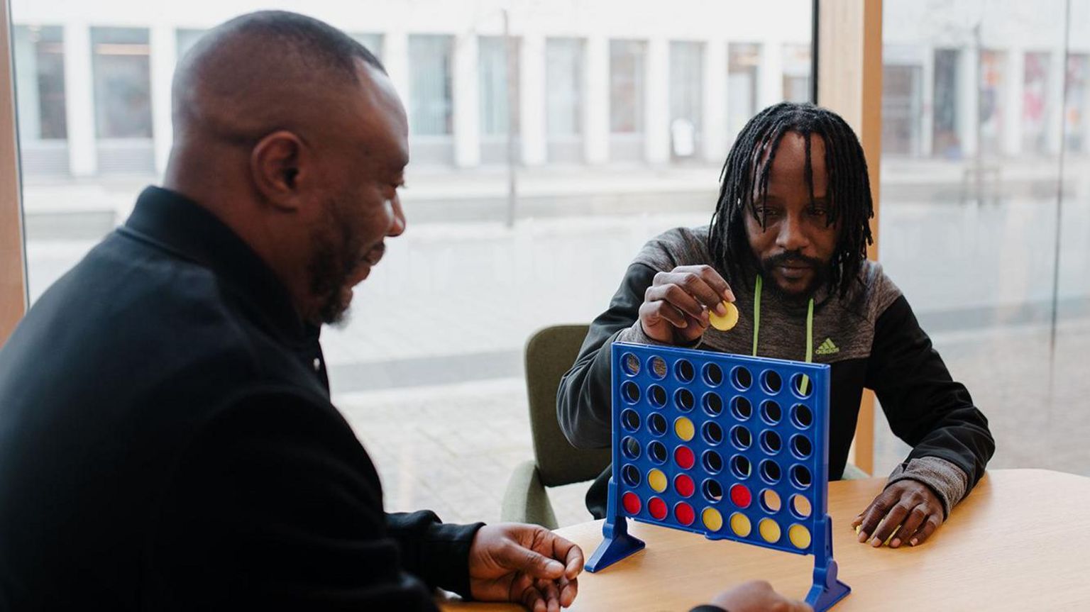 Volunteers with Beyond Detention playing Connect Four 