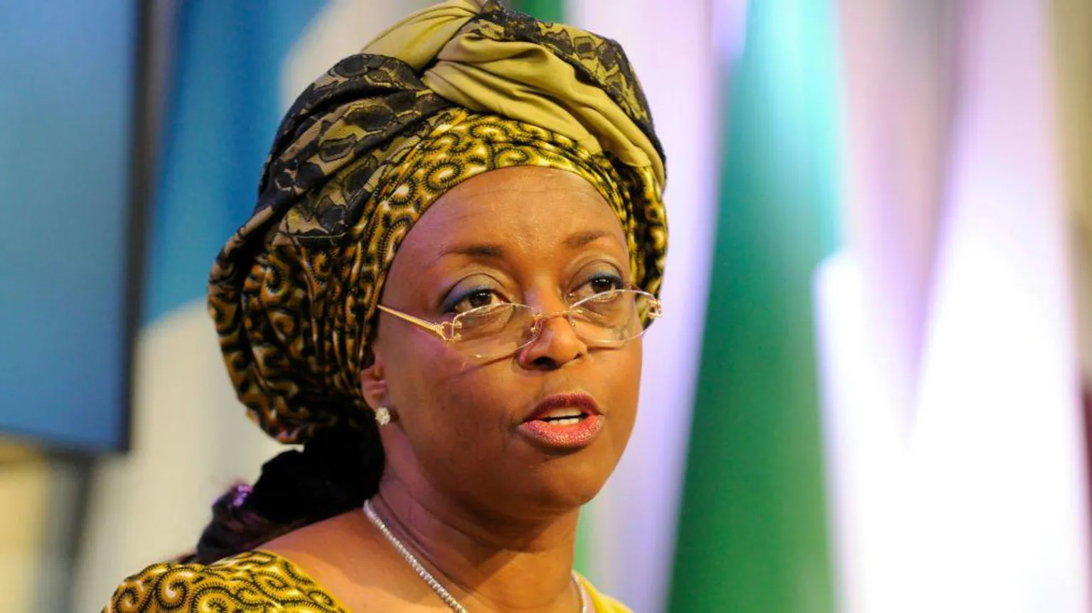 Getty Images Headshot of Diezani Alison-Madueke wearing a yellow patterned dress with headdress and glasses.