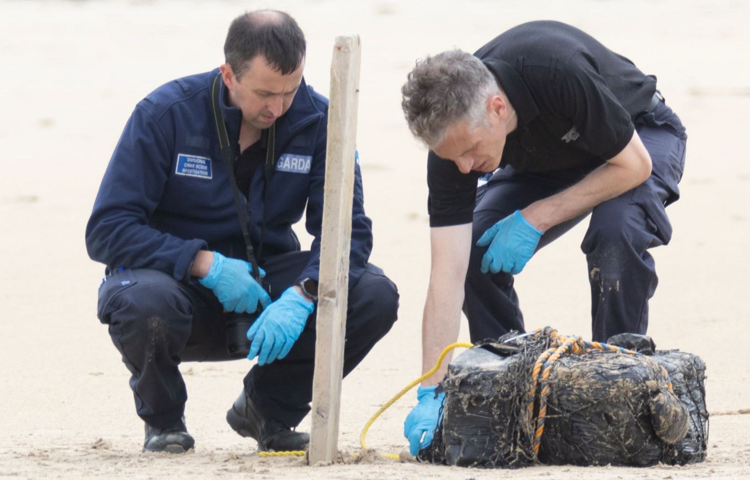 Garda officers examine a packet of suspected cocaine on a Donegal beach