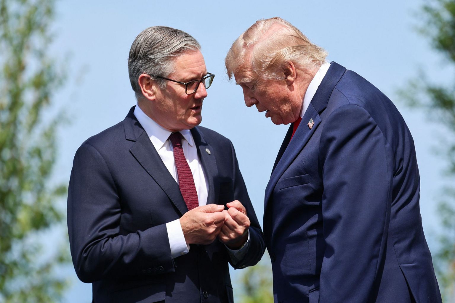 英国首相基尔·斯塔默（左）与美国总统特朗普（右）于2026年6月16日在法国东部埃维昂举行的七国集团（G7）峰会期间，参与全体合照时交谈。