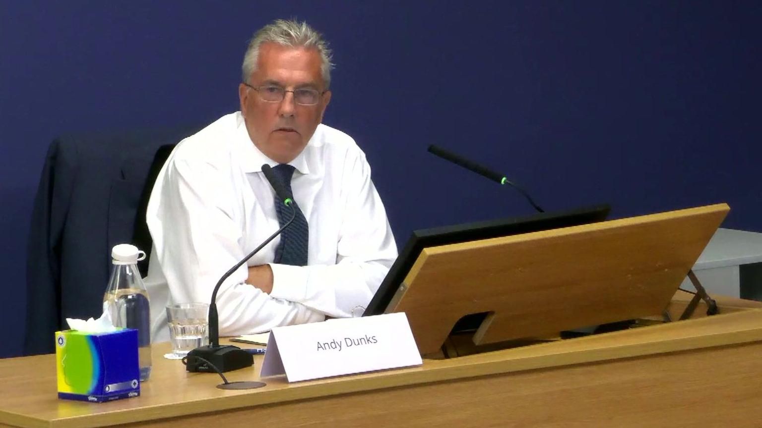 Andy Dunks, a Fujitsu IT security analyst, giving evidence at the Post Office Horizon inquiry wearing a white shirt, blue tie and glasses