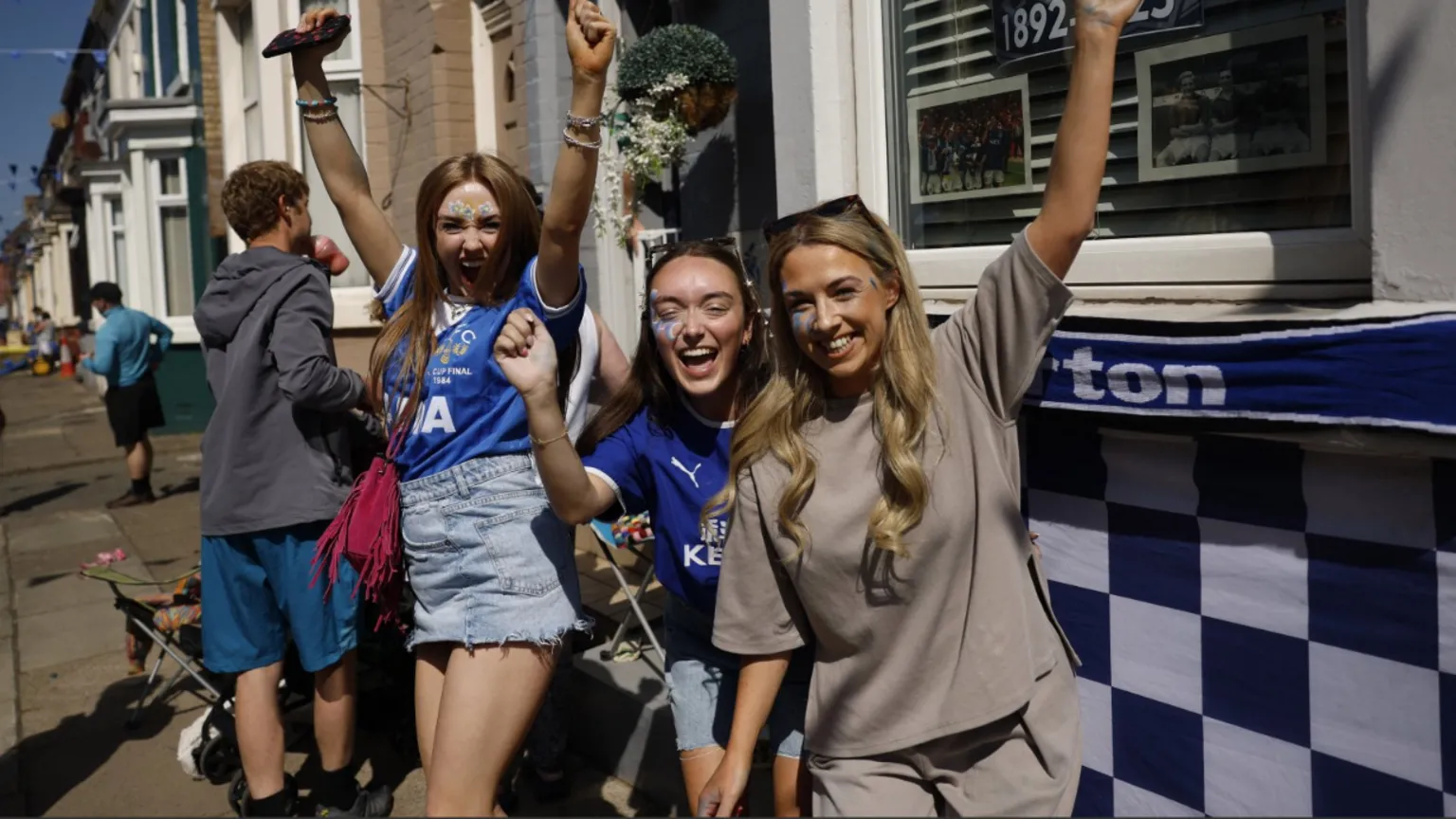 Reuters A group of three Everton fans cheering near the ground