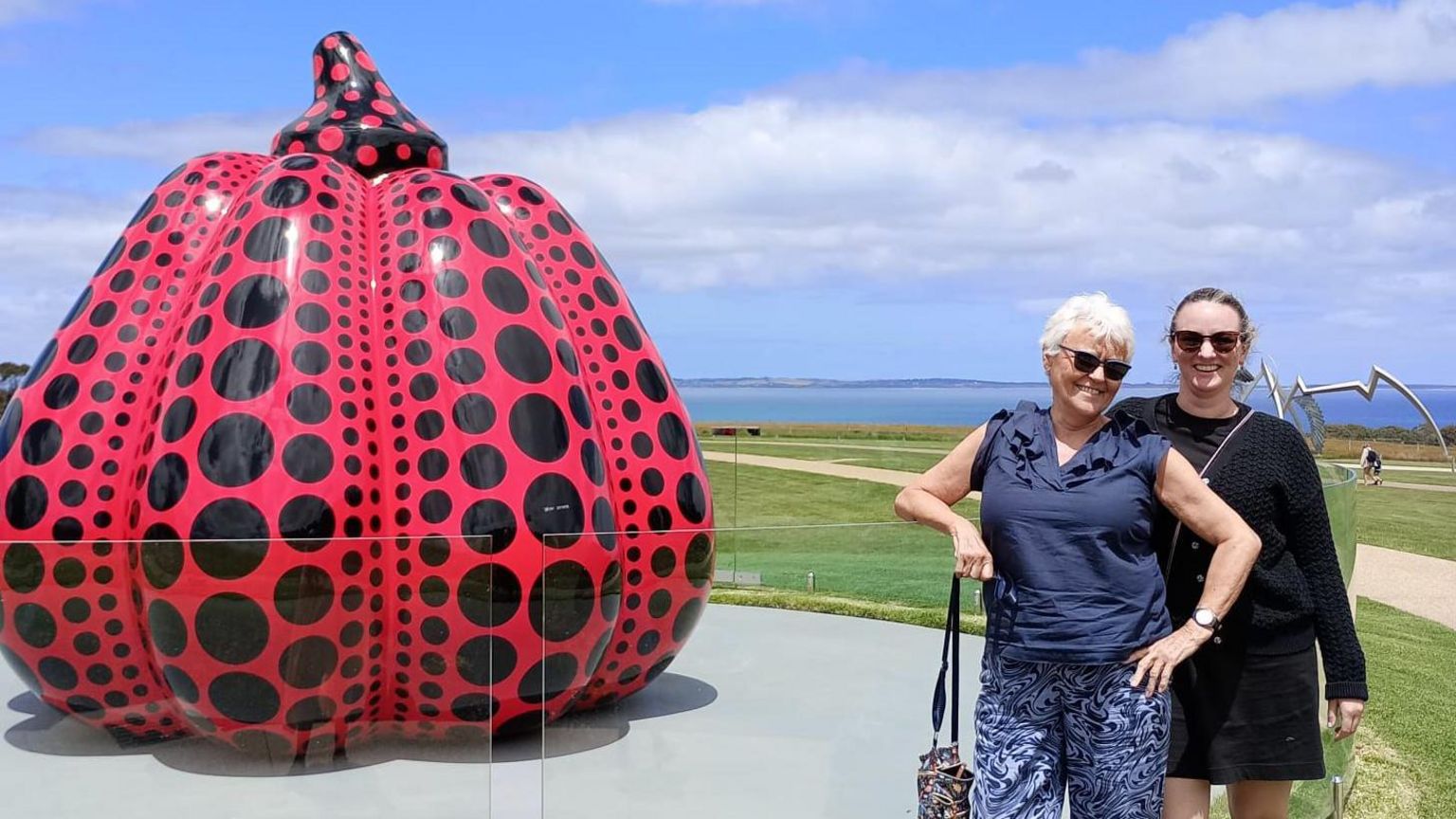 Mu Goode with her daughter Abby in front of a red sculpture in Australia 