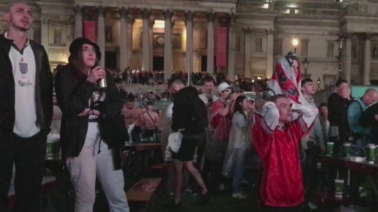 Fans look disappointed in Trafalgar Square as they watch a screen during a Euro 2021 match