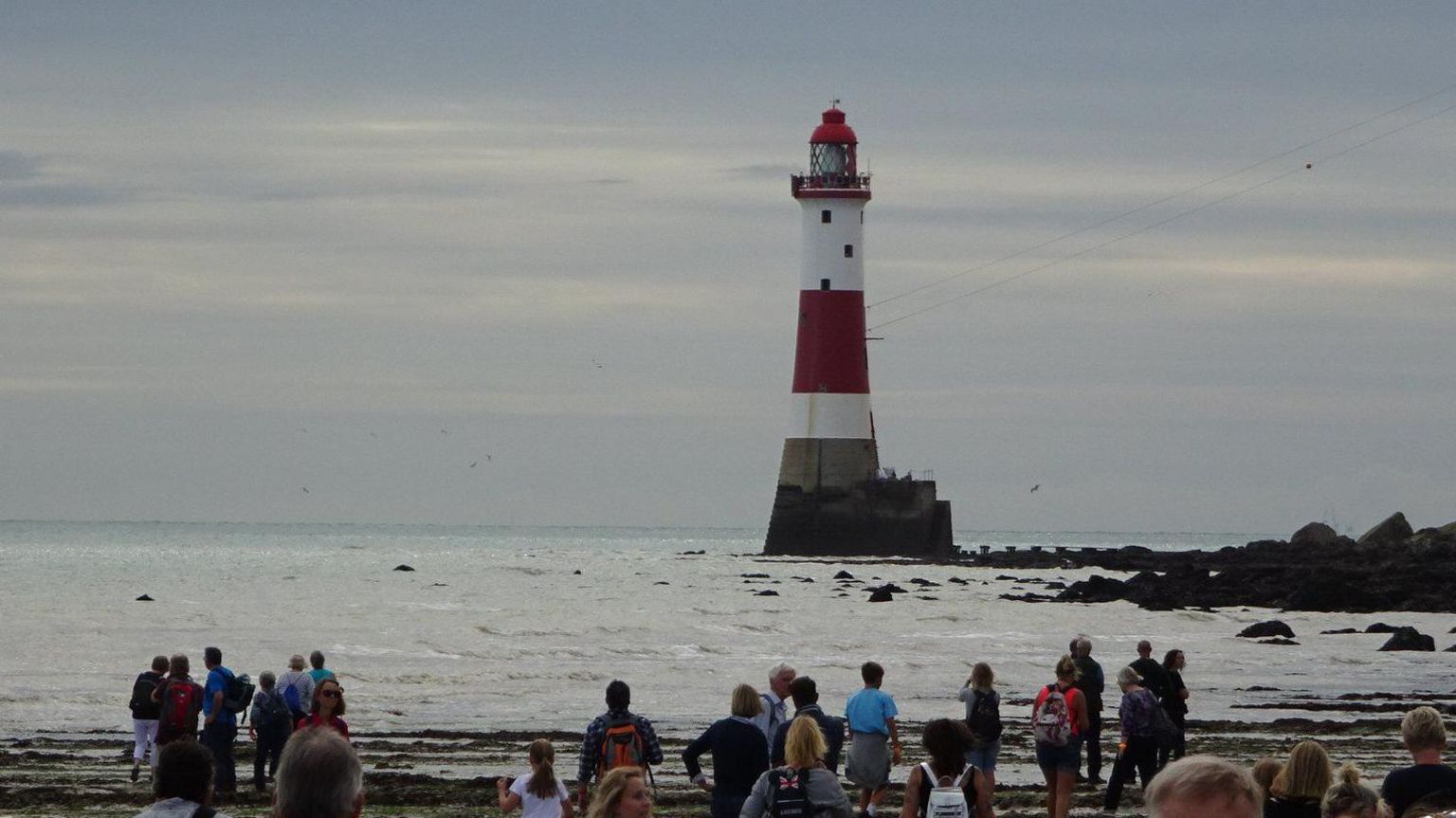eastbourne-walkers-trek-around-lighthouse-during-rare-low-tide-bbc-news