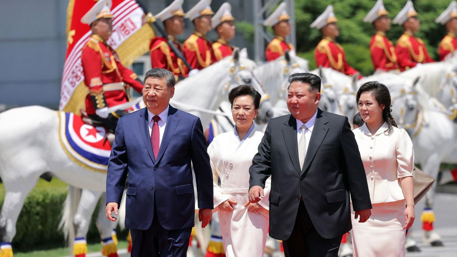 朝鲜领导人金正恩(右二)与其妻子李雪主(右)在平壤金日成广场为中国国家主席习近平举行的欢迎仪式期间,与习近平(左)及其妻子彭丽媛(左二)一同步行。