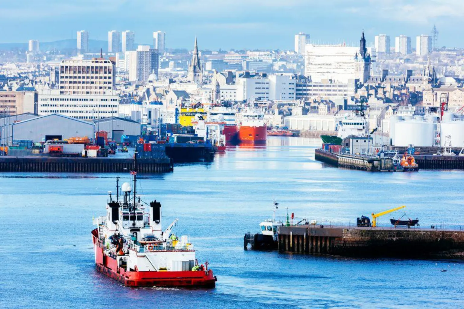 Getty Images A vessel sailing into Aberdeen Harbour, further boats are in the distance along with the city skyline, including several high-rises.