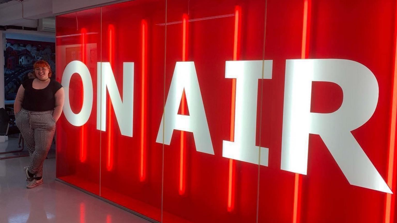 Megan Hayward standing next to an On Air sign