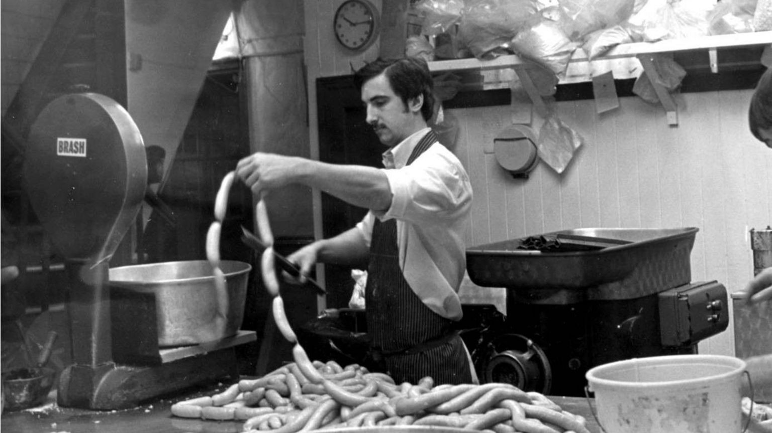 Black and white picture of a man making sausages