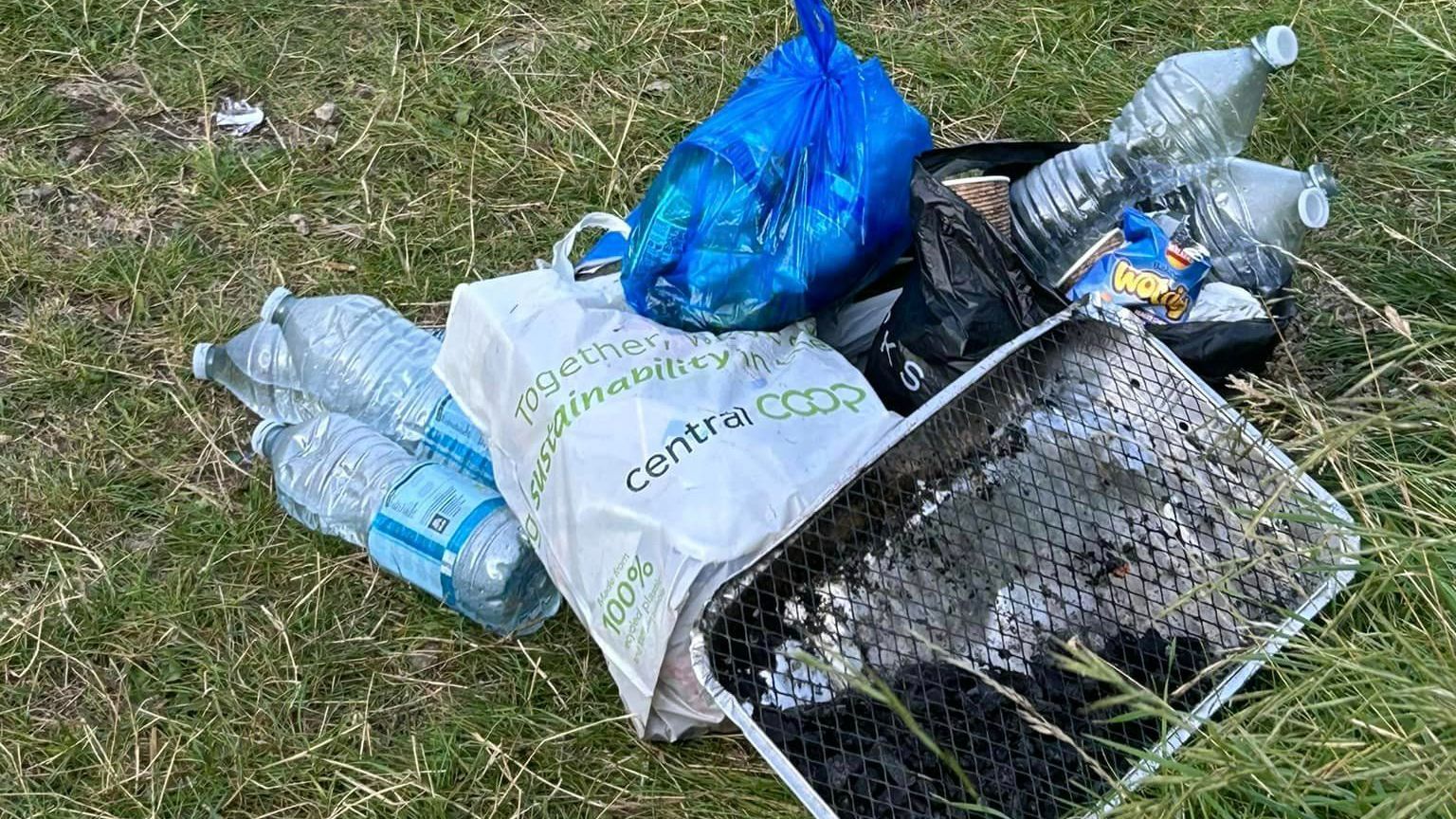 Water bottles, a barbecue and carrier bags full of rubbish