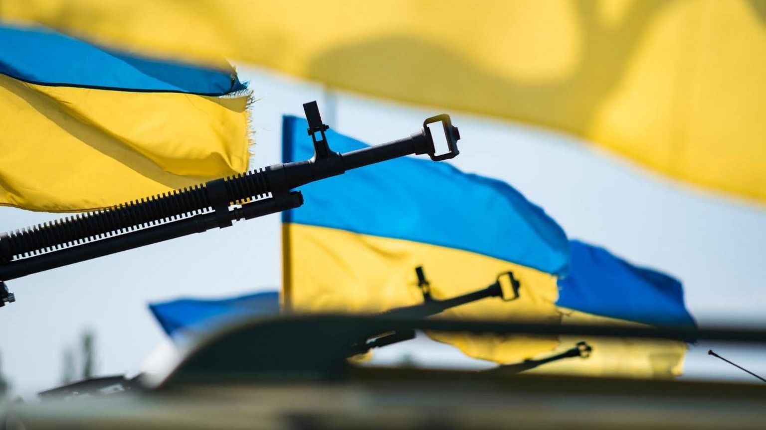Ukrainian flags blowing in the wind and guns pointed upwards