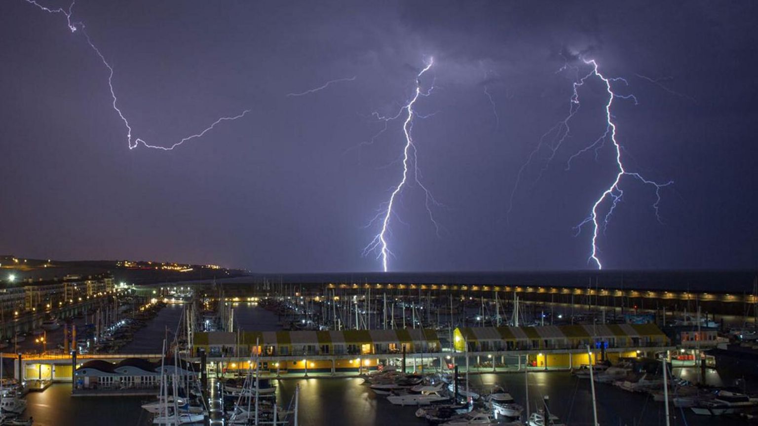 Lightning flashes across the night sky over a marina in Brighton amid thunderstorms.